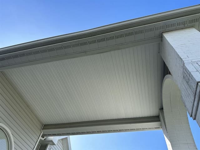 Beadboard-style soffit with continuous vent strip over a covered porch.