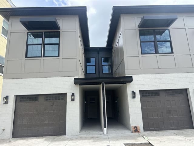 Paired townhomes with dark brown soffit, fascia and window canopies.