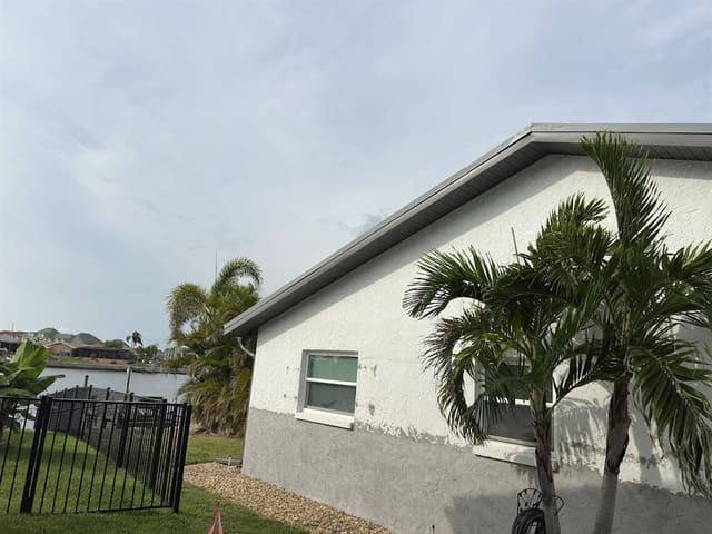 Gray vented soffit and fascia on a waterfront home's gable end.