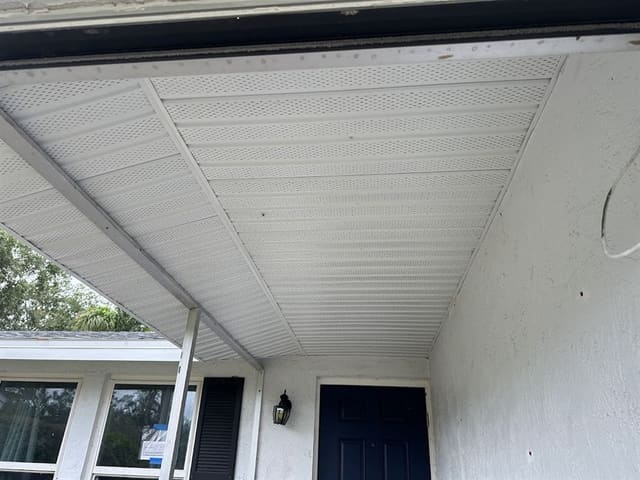 White perforated aluminum soffit covering a covered porch ceiling.