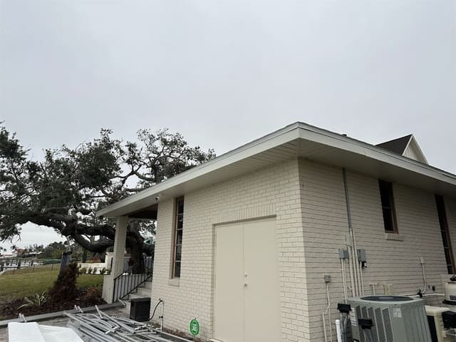 Clean white fascia line along the eave of a cream brick home.