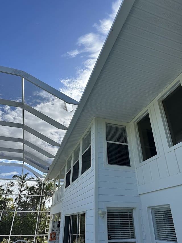 Long white vented soffit run on a two-story home next to a pool enclosure.